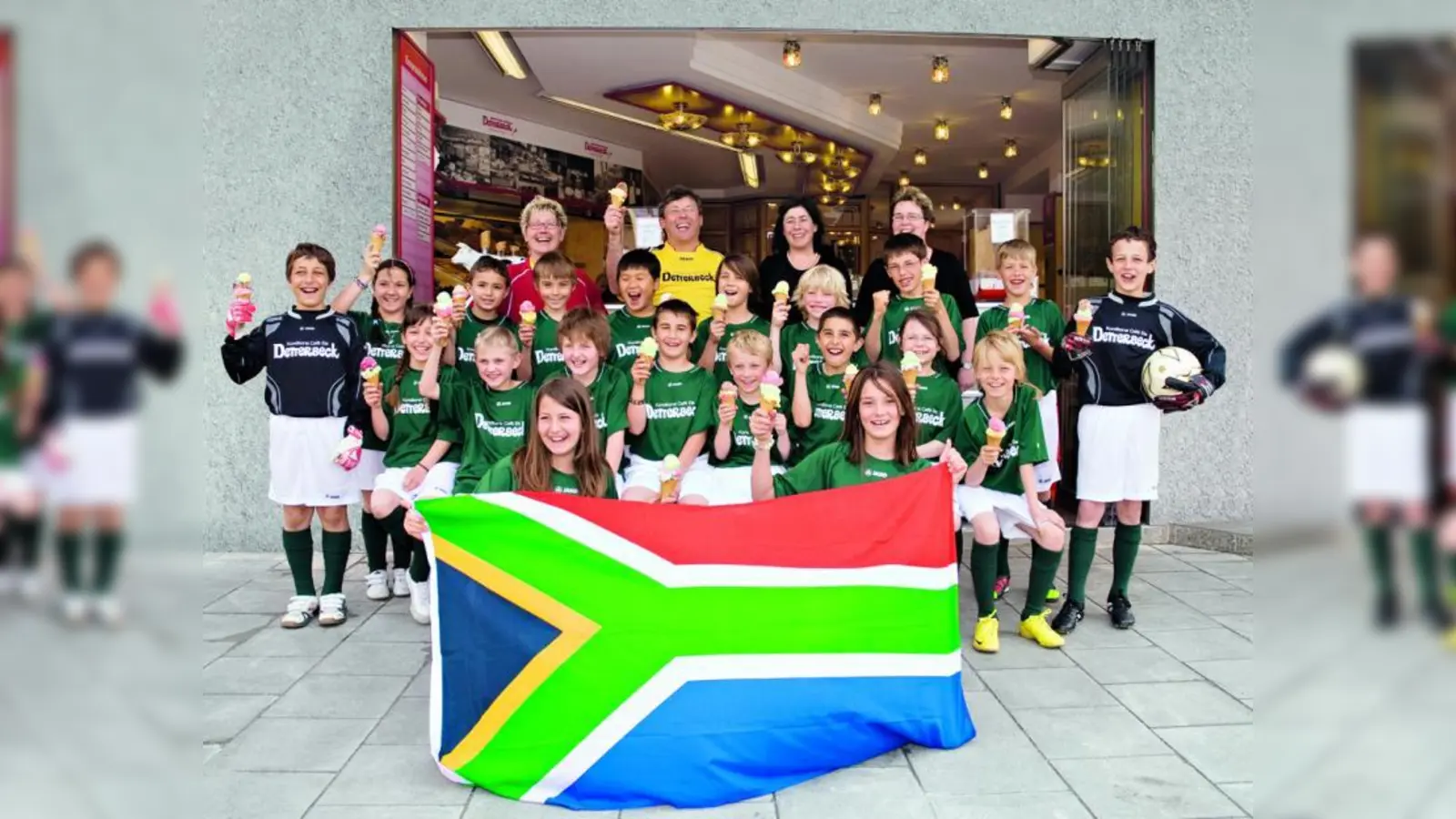 Trikotübergabe mit südafrikanischer Fahne und leckerem Eis: das Mini-WM-Fußball-Team vom Kinderhort Riegerhofweg mit (hinten v.l.) Betreuerin Manuela Rotter, Thomas und Angelika Detterbeck und einer Elernvertreterin. (Foto: pi)