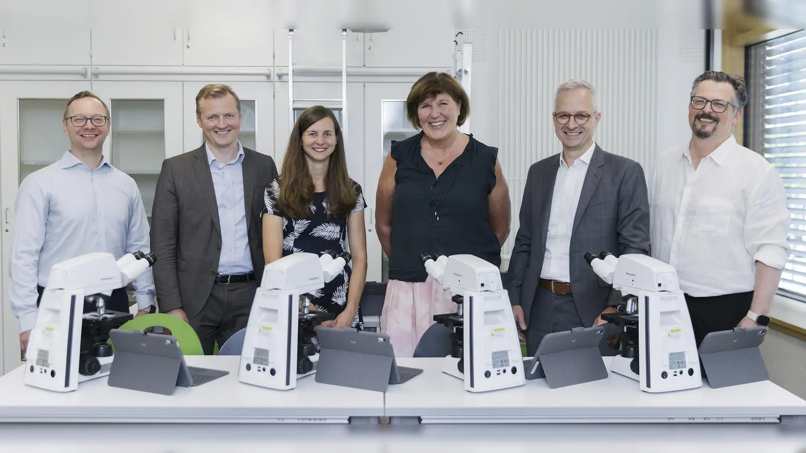 Freude bei der Übergabe der Mikroskope (von links): Dirk Pester (Vorsitzender des Fördervereins des Städtischen Thomas-Mann-Gymnasiums München e.V.), Robin Schmidt (Head of Digital Health Medical Technology), Karolin Dautermann (MINT-Koordinatorin und Fachleitung Biologie des TMG), Karin Moritz (Schulleiterin des TMG), Peter Amend (Head of ZEISS Digital Partners), Leo Pfeifenberger (Head of Software Development Microscopy). (Foto: Das Kraftbild / ZEISS)