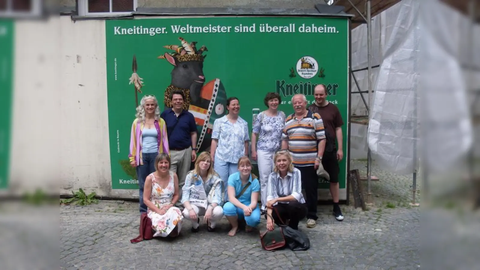 Die Reisegruppe vor einem originellen Werbeplakat der Brauerei Kneitinger. (Foto: pi)