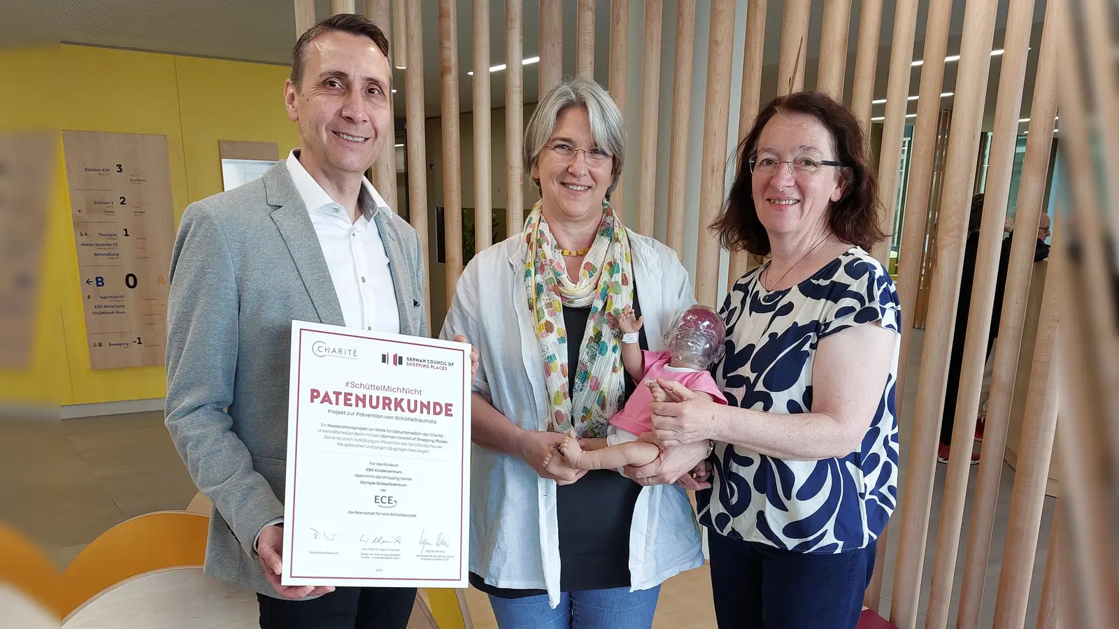Eine Schüttelpuppe für die Münchner Schreibbabyambulanz: Torsten Keller, Center Manager der ECE Marketplaces, bei der Übergabe der Simulationspuppe an Dr. MargretZiegler (rechts) und Ruth Wollwerth de Chuquisengo (Mitte). (Foto: kbo)