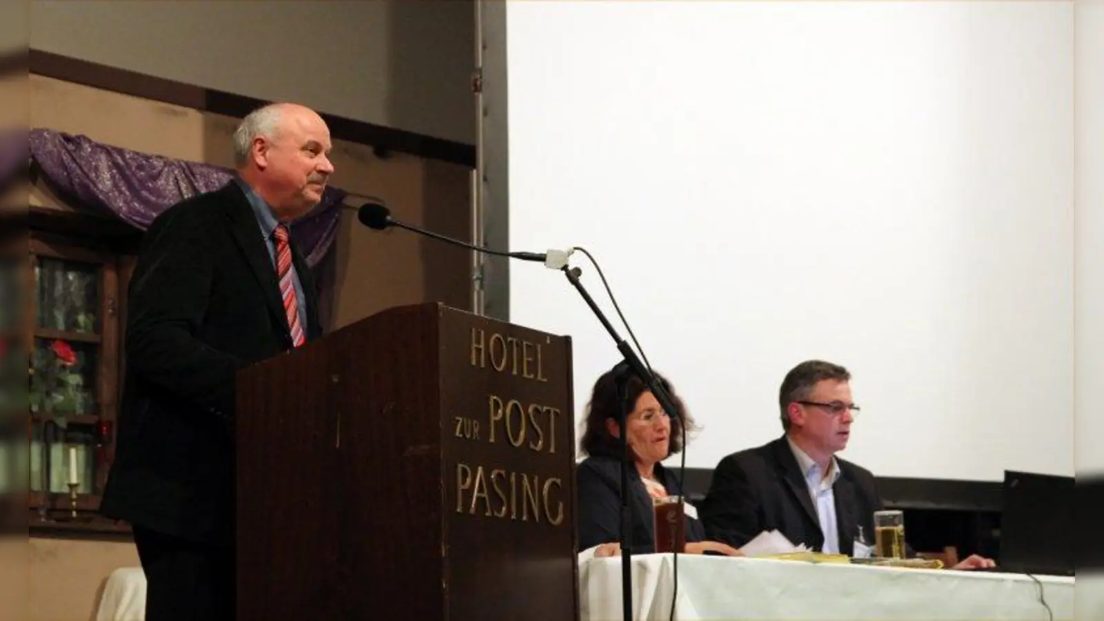 Romanus Scholz, Bezirksausschussvorsitzender von Pasing-Obermenzing, bei seinem Rechenschaftsbericht vor der Bürgerversammlung (Foto: us)