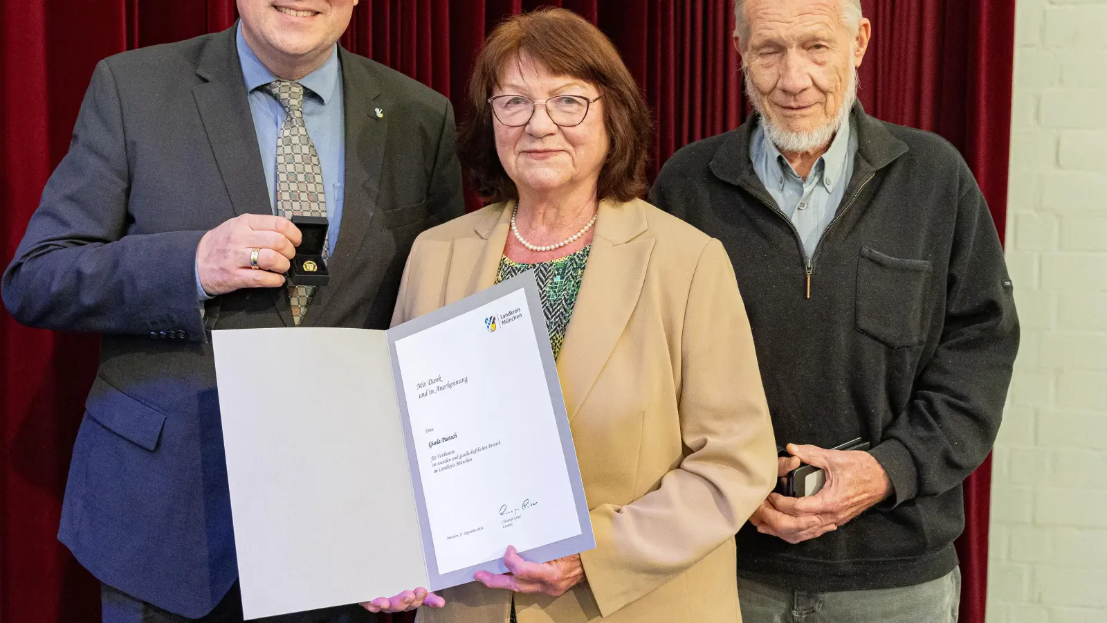 Aus den Händen von Landrat Christoph Göbel (links) erhielt Gisela Paetsch die Goldene Ehrennadel des Landkreises, rechts Ehemann Volker Paetsch. (Foto: Robert Kiderle)