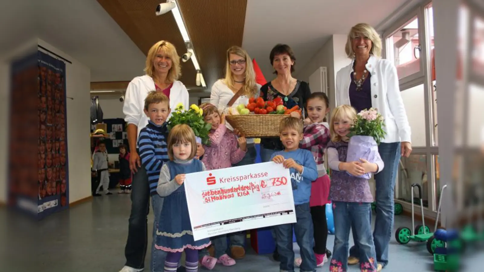Kiga Leitern Andrea Faltermeier (li.),  ihre Stellvertreterin Nina Schmidt (re.) und die Kinder nahmen mit großer Freude den Scheck der Händlervertreter Veronika Stenz (mi.li.) und Astrid Keese (mi.re.) entgegen. (Foto: mb)