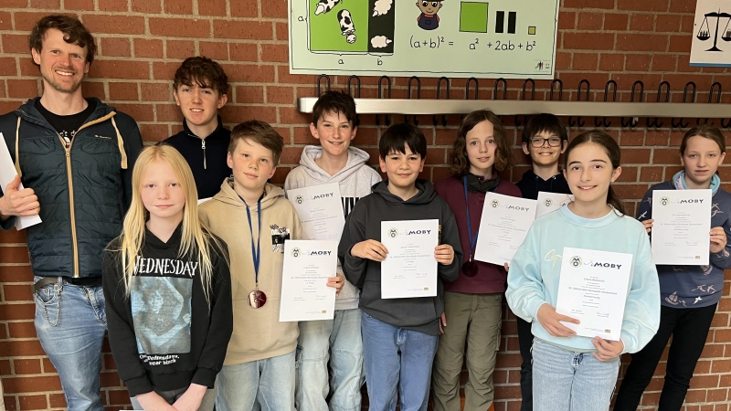 Tobias Schröttinger (Fachschaftsleiter Mathematik) freut sich mit Lena Gebauer, Ben Schwaneberg, Lukas Uhlmann, Mateo Uhlmann, Jonas Froschmeier, Dominik Ringler, Neven Parapanis, Liliana Bidzishviliund Evi Baumgärtner über die Erfolge (v.l.)<br>  (Foto: Gymnasium Dorfen)