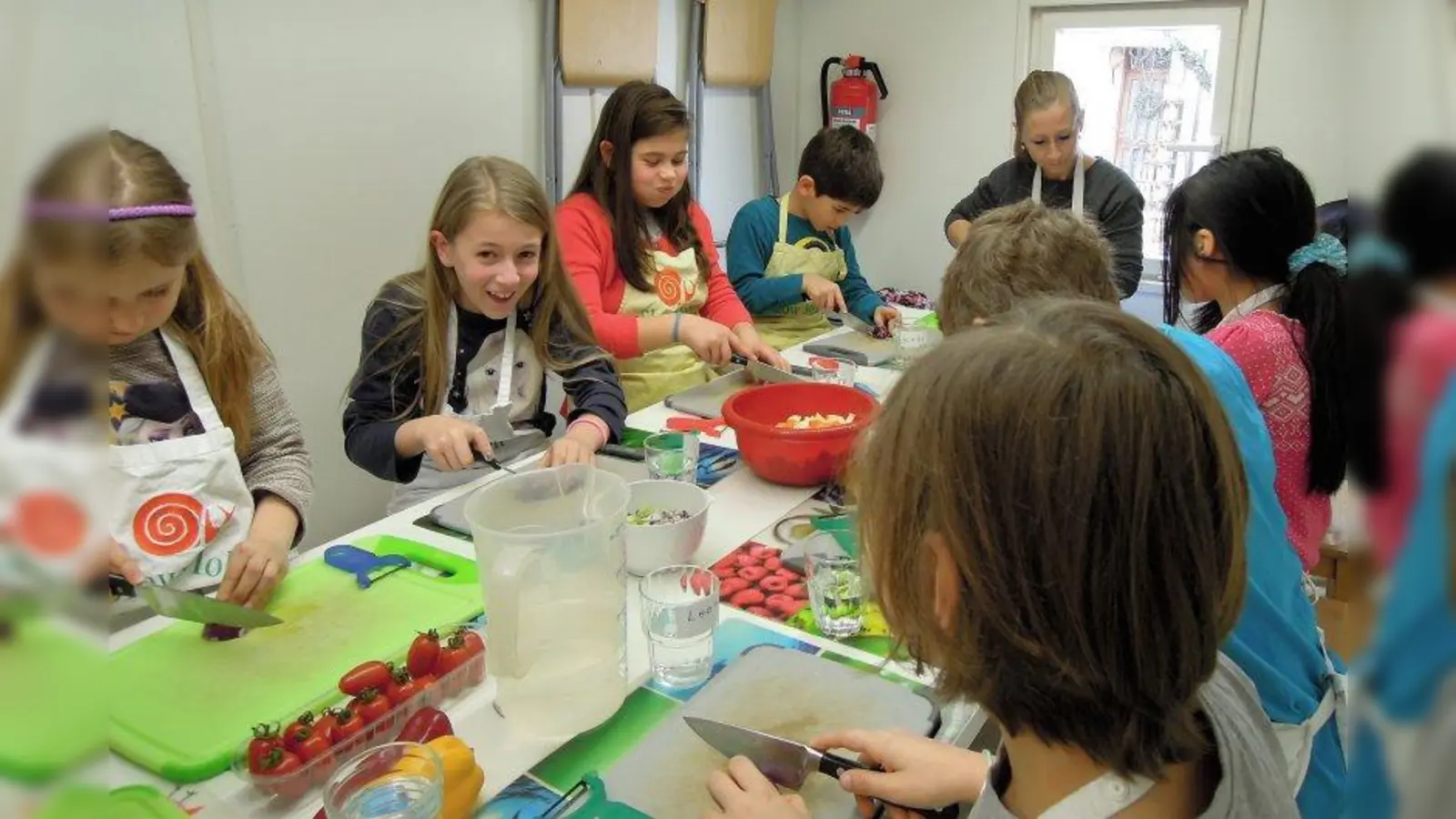 Selbst Tränen beim Zwiebelschneiden störten nicht die gute Stimmung aller Beteiligten. Die acht Kinder, Koch Markus Vouilleme und Hortbetreuerin Manuela Knott hatten in der mobilen Küche des Slowmobils einen wunderschönen Kochvormittag. (Foto: jb)