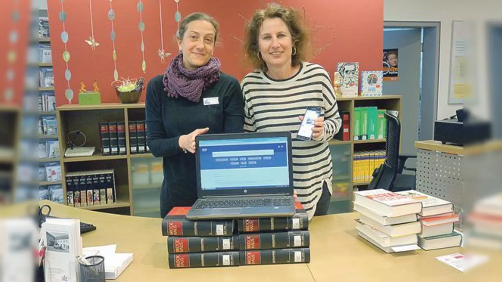 Daniela Raif und Gabriele Oswald vom Grünwalder Bibliotheksteam bieten neben dem Brockhaus in Buchform jetzt auch das geballte Wissen in einer Online-Version an. 	 (Foto: hw)