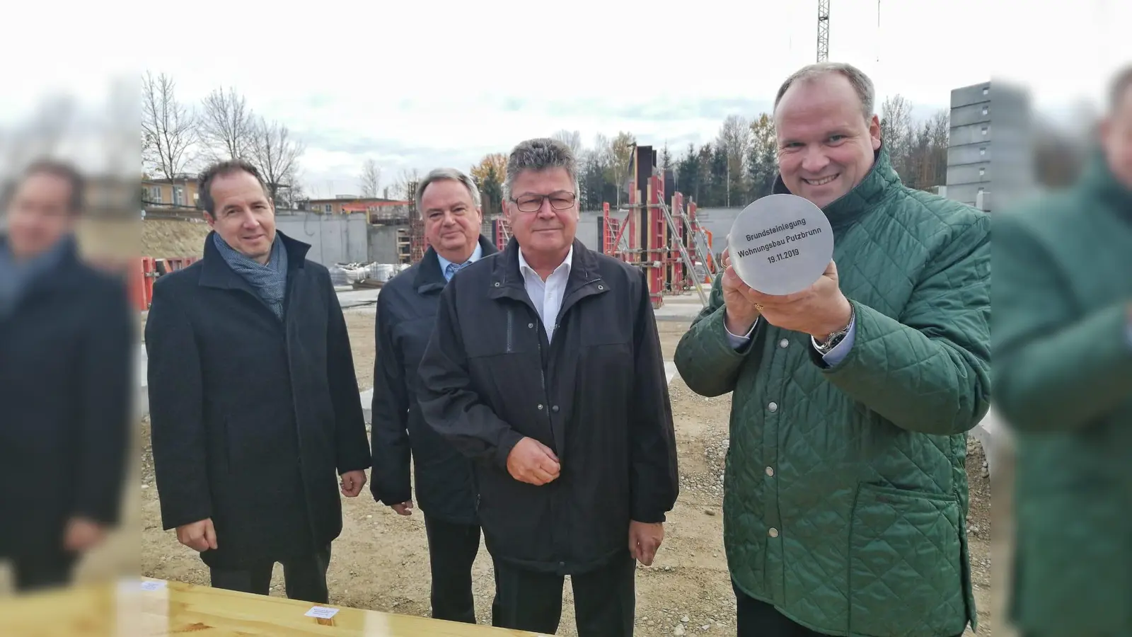 Präsentieren die fertig gefüllte Plombe: (v. r.) Landrat Christoph Göbel, Putzbrunns Bürgermeister Edwin Klostermeier, Ulrich Bittner (Geschäftsführer Baugesellschaft München-Land) und Michael Amberg (Höss Amberg + Partner Architekten mbB). (Foto: LRA)