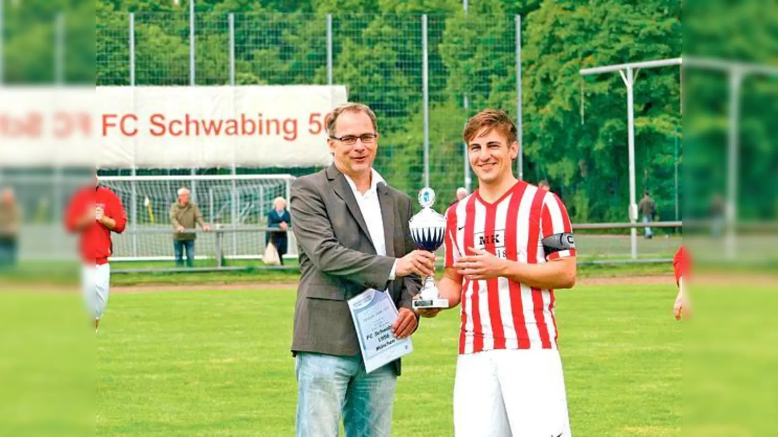 Yannick Krieger nahm die Trophäe für die Kreisligameisterschaft von Bernhard Slawinski, BFV-Kreisvorsitzender München entgegen.	 (Foto: Verein)