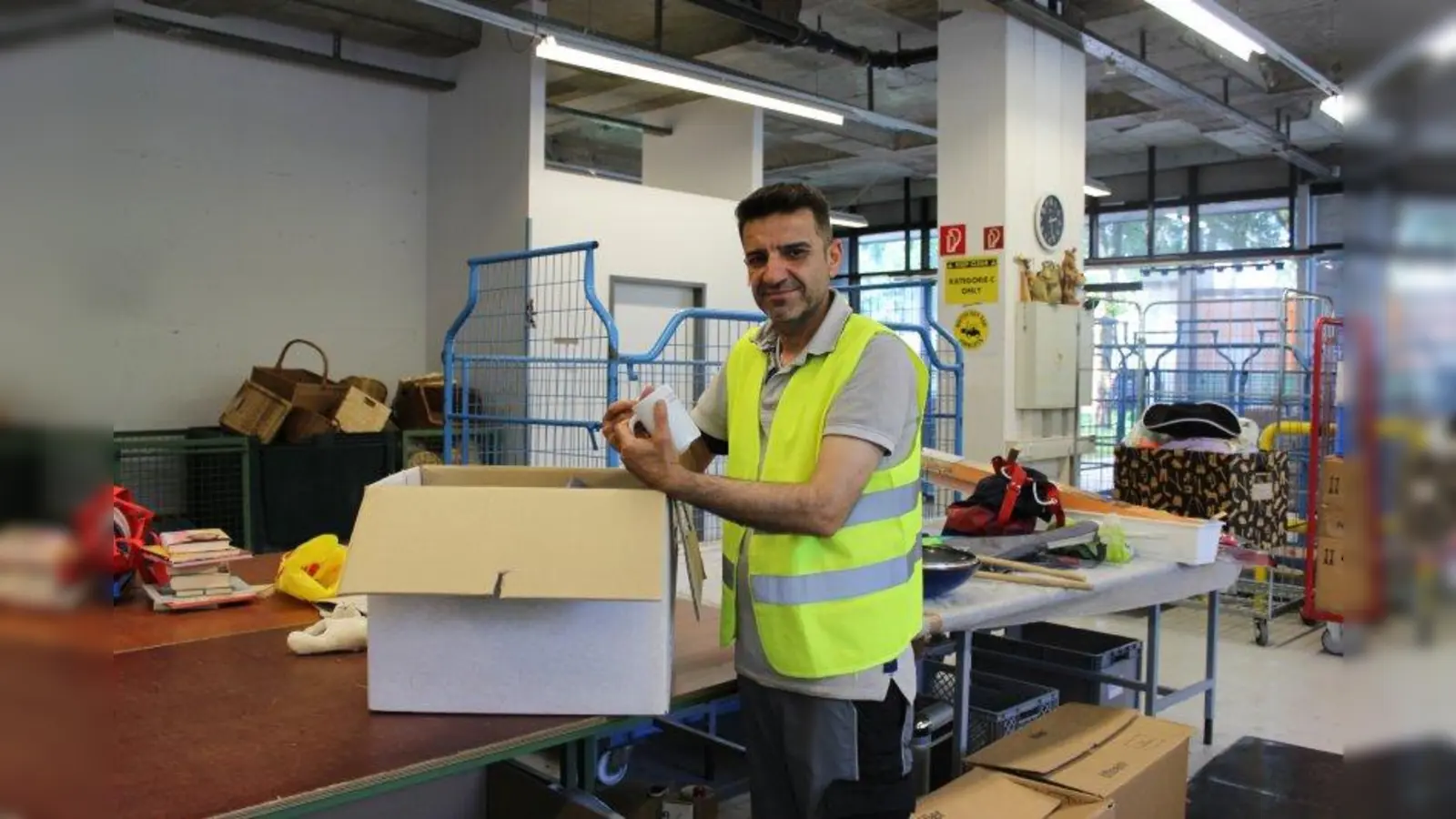 Mohammed Abas, arbeitet in der Spendenannahme: „Ich sortiere Hausrat, also alles angefangen von Gläsern, Tassen, Tellern, Besteck bis hin zu Spielzeug. Seit zwei Jahren arbeite ich hier und es gefällt mir gut. Die Arbeit passt zu mir, ich liebe sie sehr. Auch meine Kollegen sind alle sehr nett. Wir haben ein wunderbares Verhältnis und einen guten Zusammenhalt. Ich komme aus dem Irak und bin seit neun Jahren in Deutschland. Zuvor habe ich fünf Jahre nicht gearbeitet und war nur zu Hause bei meiner Familie, konnte nicht mehr essen und schlafen. Jetzt bin einfach nur froh, hier sein zu dürfen. Alles läuft sehr gut. Es ist zudem toll, dass es die Sozialberatung gibt. Sie hilft mir sehr, wenn es nötig ist. Ich danke Gott jeden Tag, dass ich diese Arbeit gefunden habe. Endlich geht es mir wieder besser.“ (Foto: sb)