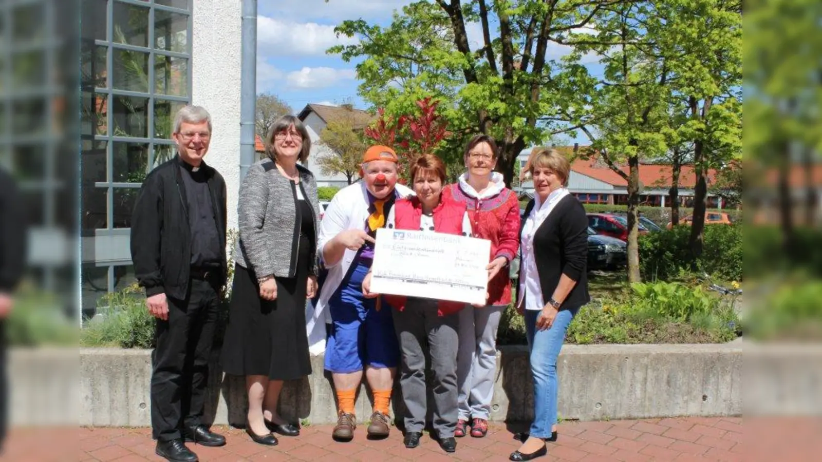 Dr. Tröööt von den KlinikClowns (3.v.l.) zusammen mit Marianne Weigl (3.v.r.) Theresia Hans (2.v.r.) und Marlies Kaiser (r.) vom Katholischen Frauenbund Allach sowie Pfarrer Martin Joseph und Birgitt Siegle. (Foto: sb)