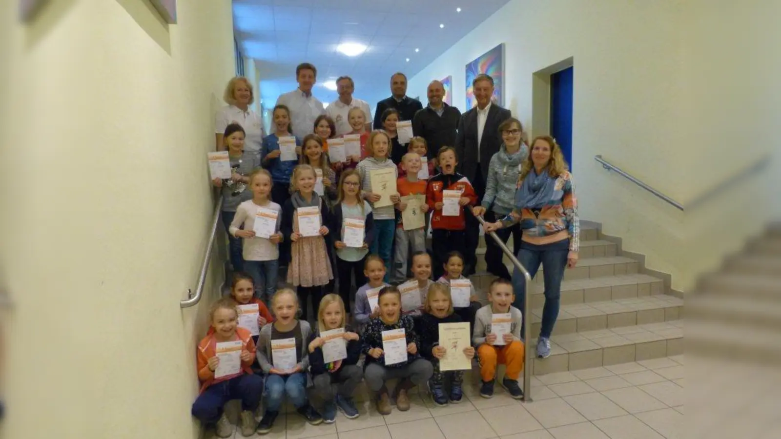 Stolz präsentieren die kleinen Sportler ihre Urkunden, die ihnen bescheinigen, dass sie das Deutsche Sportabzeichen bekommen haben. Mit ihnen freut sich unter anderem Bürgermeister Frederik Röder (hinten rechts). (Foto: Gemeinde Alling)