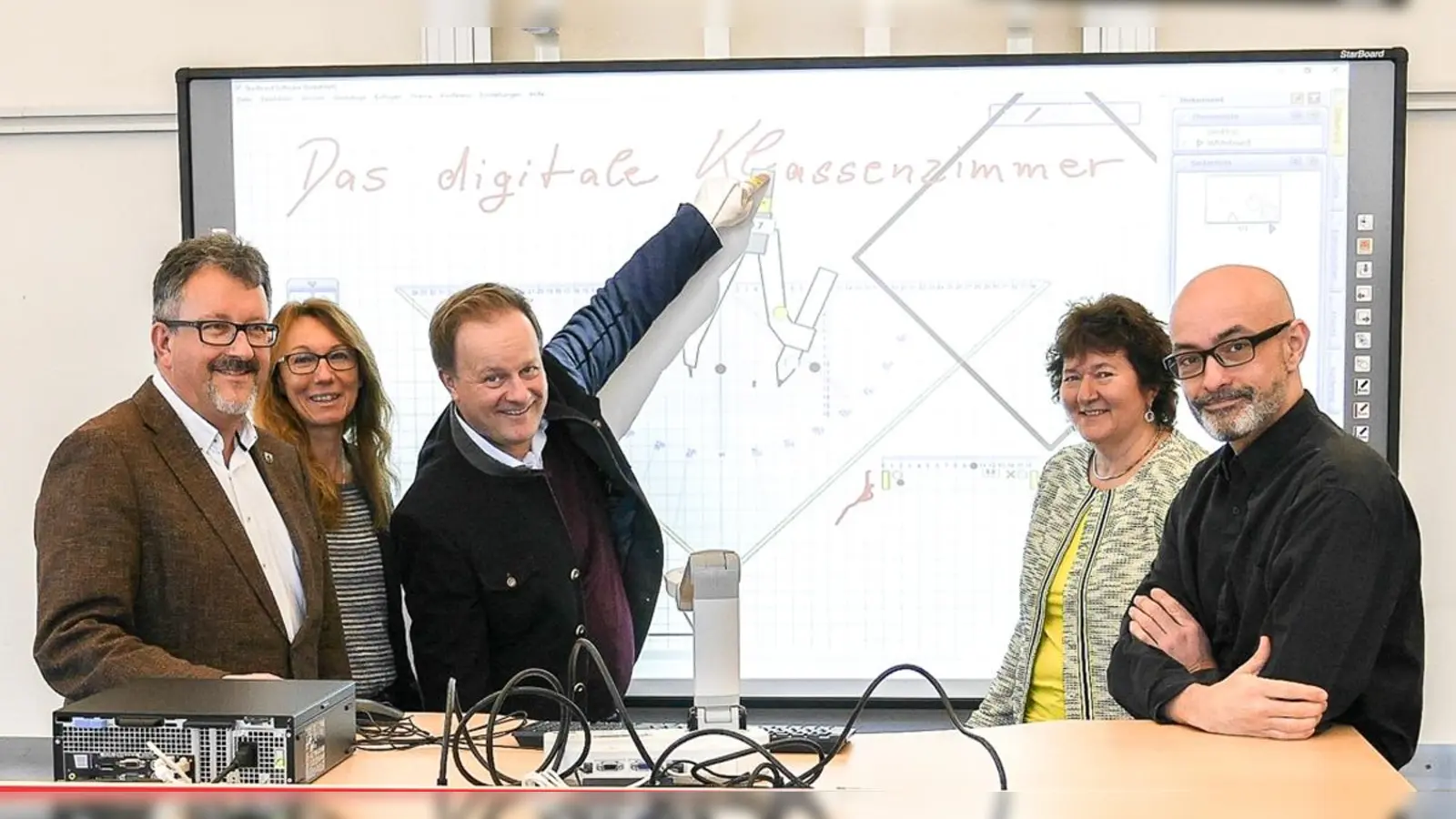 Erich Hanslmayer, Brigitte Korber, Landrat Robert Niedergesäß, Brigitte Keller sowie Hubert Schulze (von links) im Landratsamt vor einem Whiteboard im Digitalen Klassenzimmer, in dem die Landkreisschulen verschiedene Angebote testen können. (Foto: LRA)