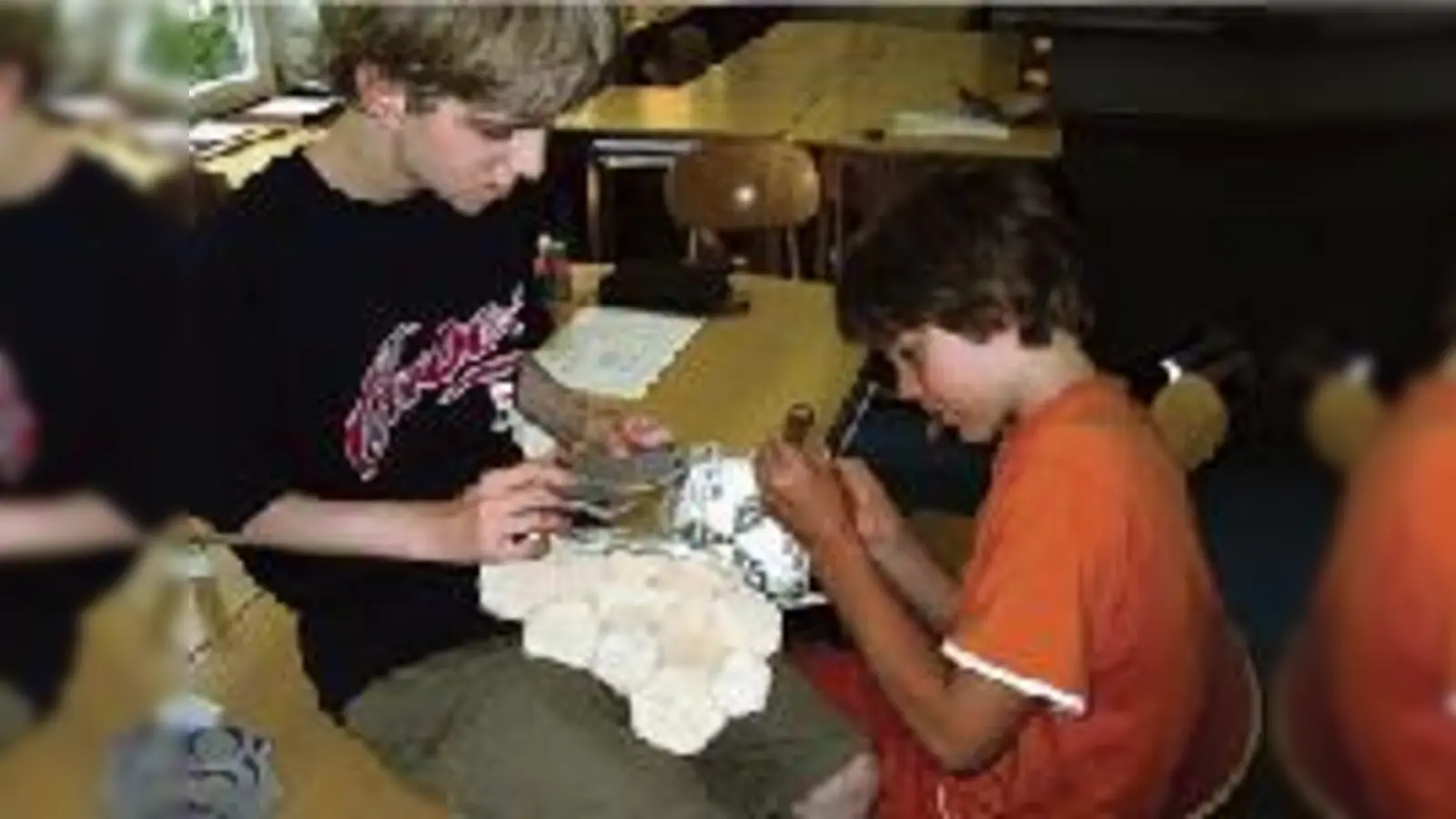Julius und Lian (v. li.) beim mühseligen Zusammennähen eines Fußballs im Rahmen des Fair-Play-Projekts ihrer Schule. 	 (Foto: Barbara Recker)