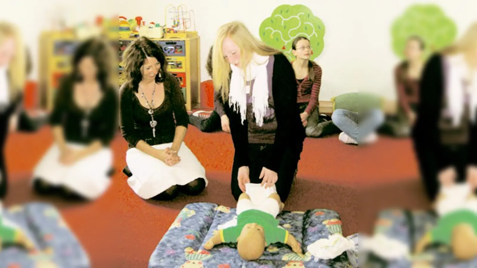 Referentin Judith Wagner mit Teilnehmerinnen beim »Wickeln-Üben«.  (Foto: Privat)