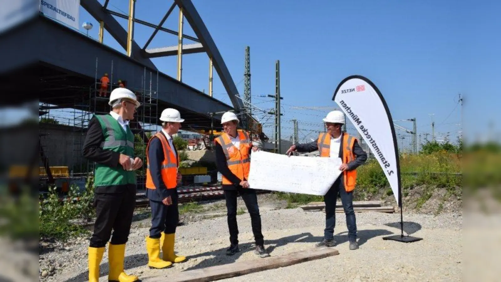 Gesamtprojektleiter Kai Kruschinski (Mmitte) und Jens Reh von der Arbeitsgemeinschaft der Baufirmen (rechts) erklärten Ministerialdirektor Helmut Schütz (Bayerisches Verkehrsministerium, ganz links) und Klaus-Dieter Josel, DB-Konzernbevollmächtigter in Bayern (Zweiter von links), wie die Stabbogenbrücke an ihre finale Stelle geschoben wird. (Foto: DB/Maximilian Endrös)
