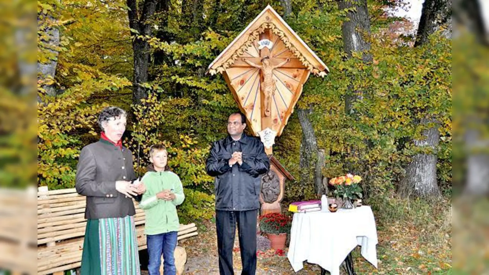 Elisabeth Reis schnitzte selbst das Südkreuz am Waldrand von Buch, hier mit dem Ministranten Kilian und Pater Georg bei der feierlichen Weihe. 	 (Foto: sf)