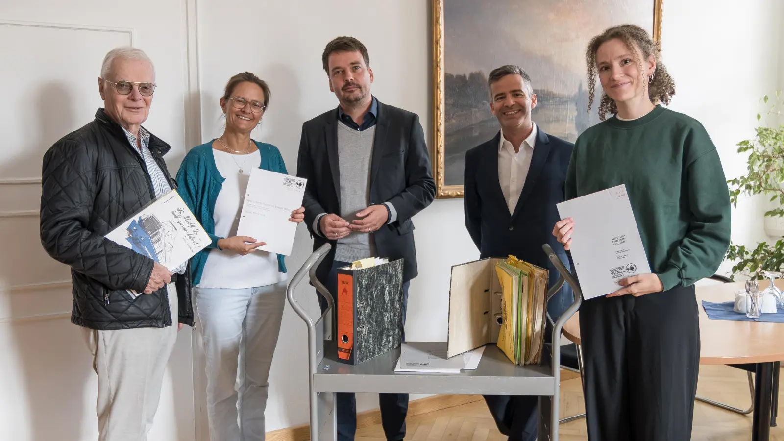 Bei der symbolischen Übergabe des Archivmaterials (v.l.): Martin Fürstenberg (Münchner Forum), Caroline Klotz (Geschäftsführung Münchner Forum), Daniel Baumann (leitender Archivdirektor, Stadtarchiv), Philip Zölls (Leitung Sachgebiet Sammlungen, Stadtarchiv) und Anna-Lena Genz (Münchner Forum). (Foto: Jörg Steffens, Stadtarchiv)