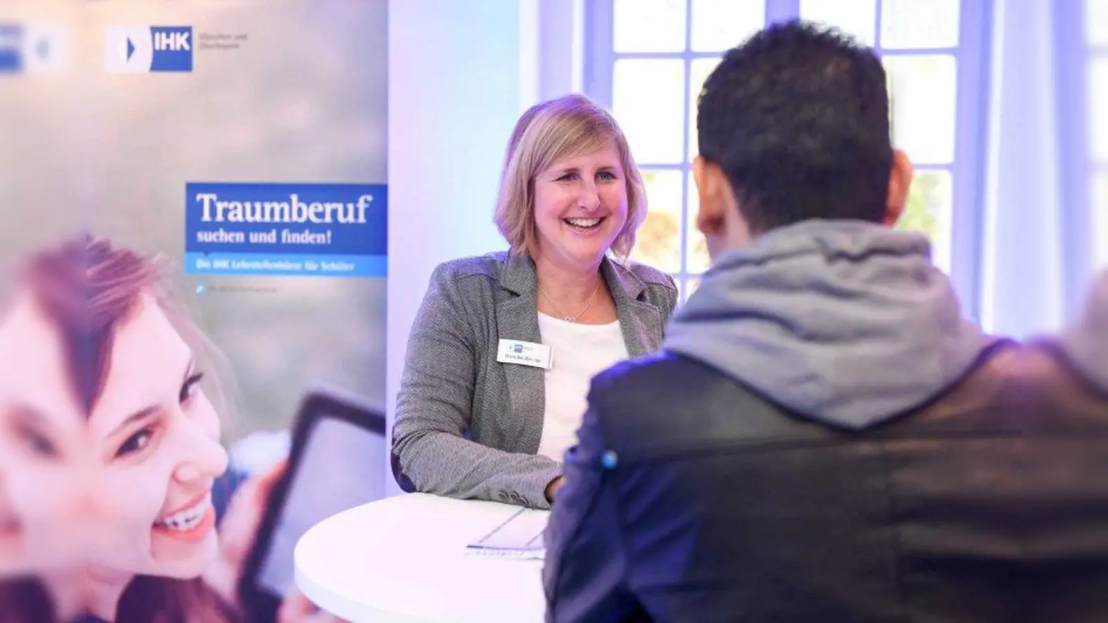 Eine IHK-Mitarbeiterin gibt einem Jugendlichen Tipps zur Berufswahl. (Foto: Tobias Hase/IHK München)