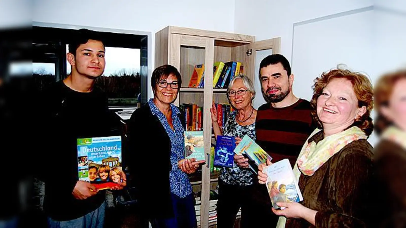 Klawotte-Leiterin Ulrike Konrads (2.v.l.), Karin Rieder vom Helferkreis Asyl (3.v.l.), Betreuer Naser Abdelghani (2.v.r.) und Koordinatorin Ursula Zenker (re.) gekommen waren, lieh sich ein minderjähriger Flüchtling (li.) das erste Buch aus.  (F: priv.)