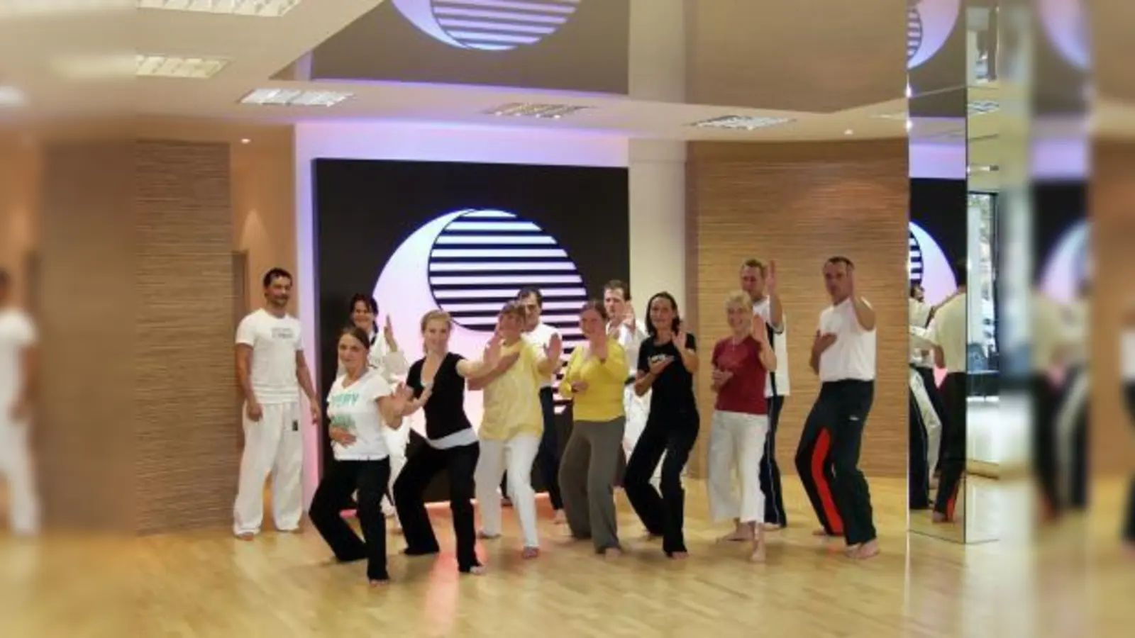 Viel Spaß hatten diese Eltern „auf den Spuren ihrer Kinder“ im Twin-Taekwondo-Center Germering, die von Schulleiter Christian Kugele (links) eine Einführung in die Philosophie des Taekwondo erhielten. (Foto: Eva Schraft)