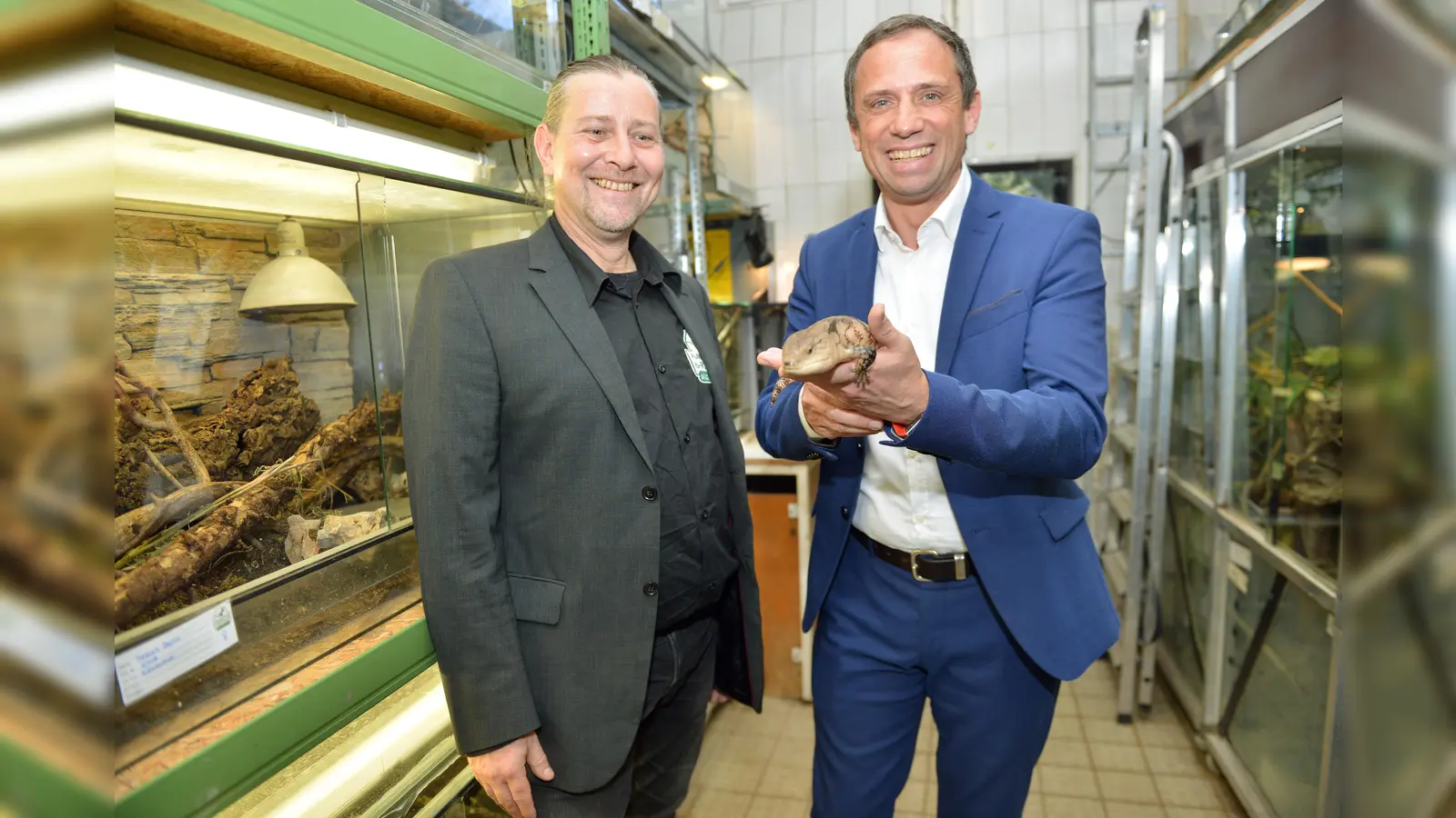 Keine Berührungsängste: Bayerns Umweltminister Thorsten Glauber (re.) hat die Reptilienauffangstation besucht und ist auf Tuchfühlung gegangen. Anlass für den Besuch war die Übergabe eines Förderschecks an Markus Baur (li.) für den Neubau der Station in Neufahrn. (Foto: BStUV)
