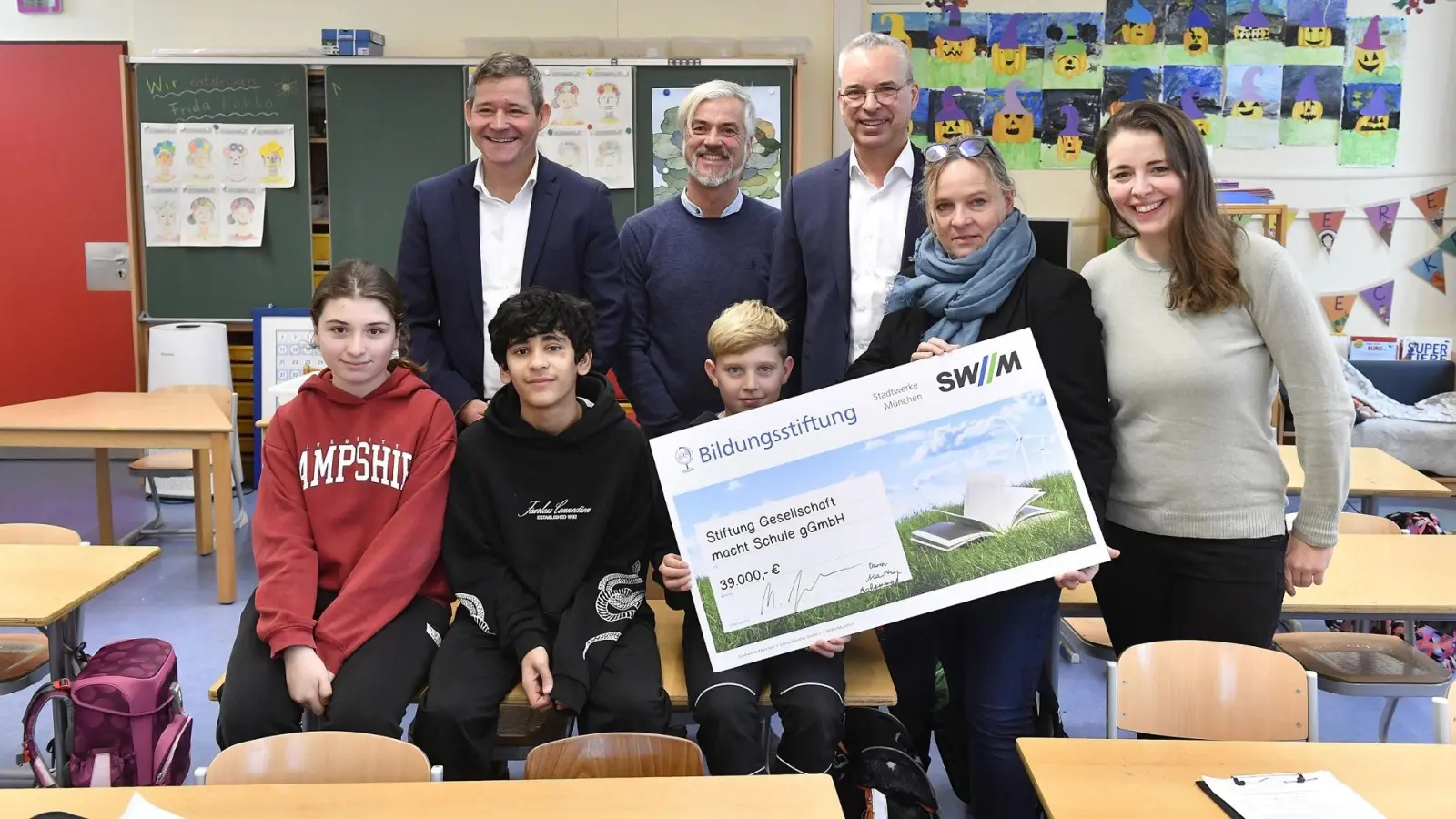 Stefan Inderst, Leiter der Walliser Grundschule, Projektleiter Markus König, und Martin Janke von der SWM-Bildungsstiftung (hinten von links) mit Darin, Mohammed und Martin aus der 4cg sowie Barbara Ruck (Geschäftsführerin Gesellschaft macht Schule) und pädagogischer Fachkraft Lucia Thüroff (vorne von links) freuen sich über die Unterstützung. (Foto: SWM)