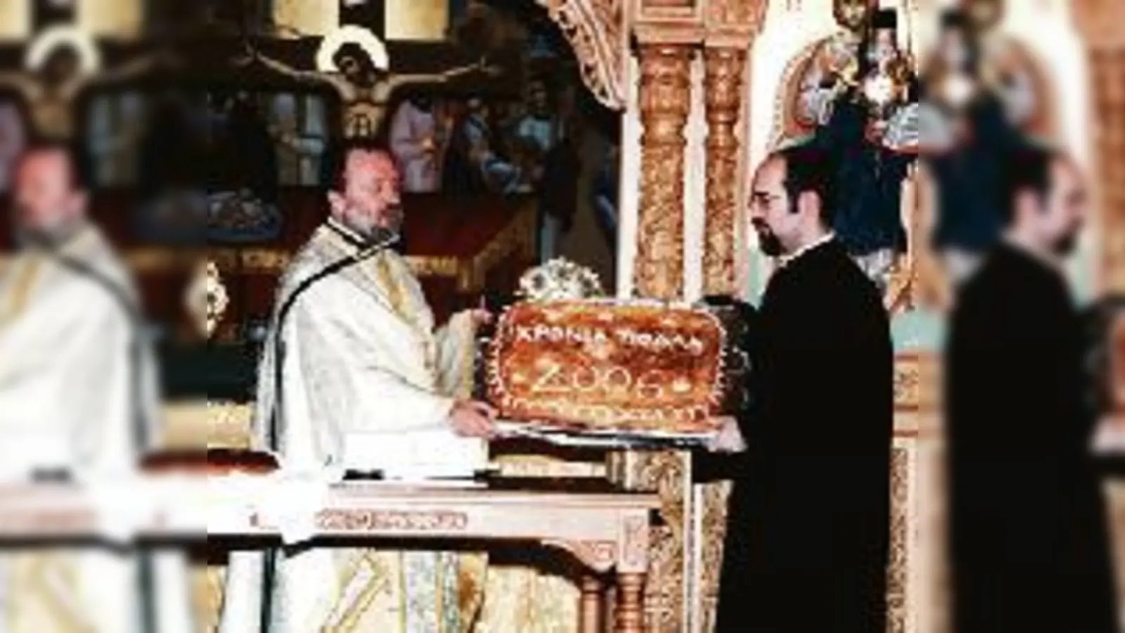 Griechische Neujahrstradition: Der Erzpriester der griechisch-orthodoxen Kirche in München, Apostolos Malamoussis (links) mit der »Vasilopita«.  (Foto: Privat)