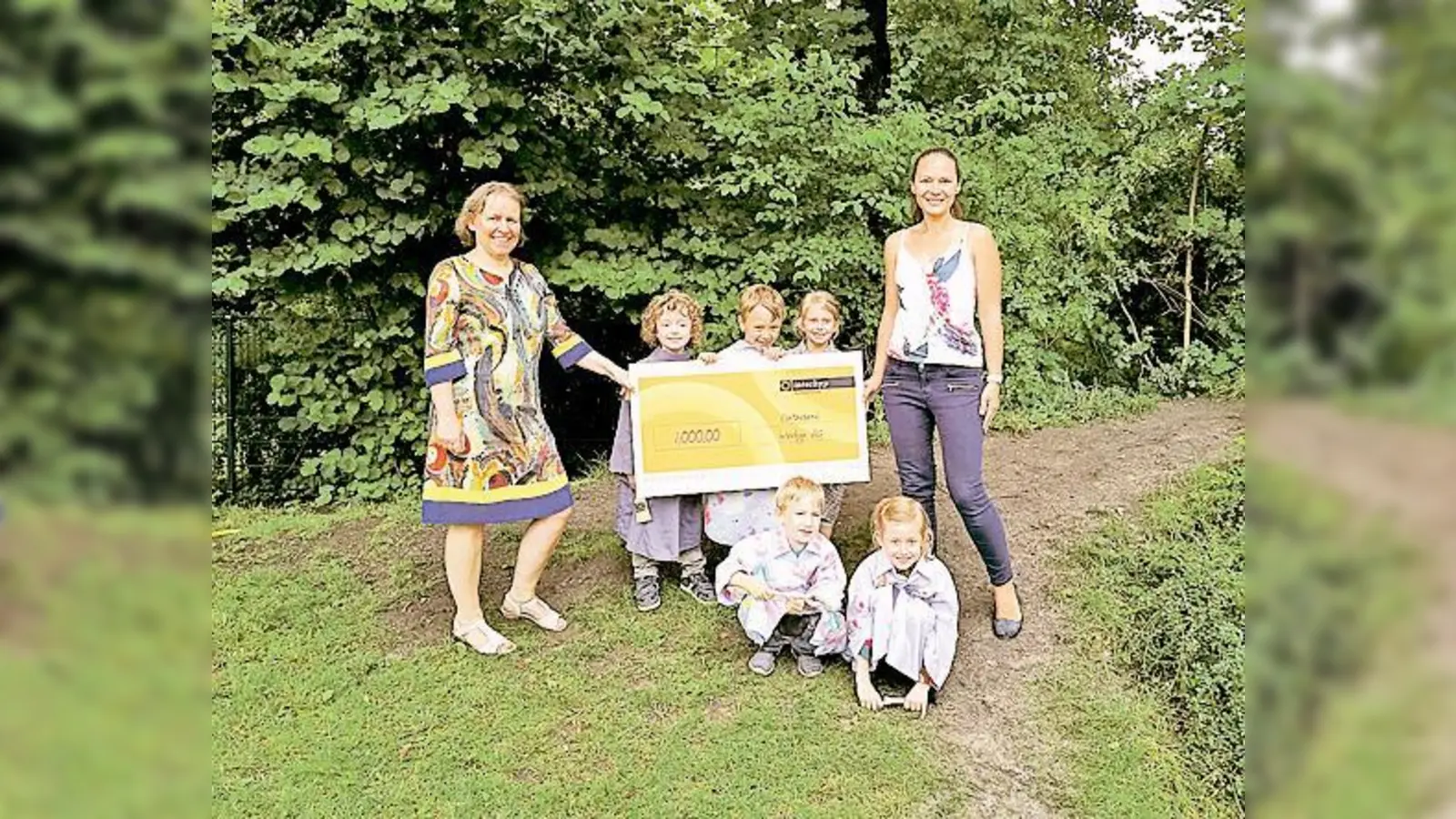 Pauline Hirmer (li.), Leiterin des Kindergartens St. Johannes, freut sich über 1.000 Euro für neue Turngeräte. Alicja Wilk (re.) von Interhyp überreichte ihr den Scheck beim diesjährigen »Künstler«-Sommerfest des Kindergartens. 	 (Foto: privat)