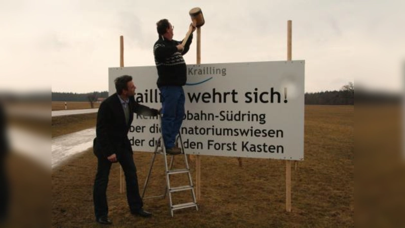Bauamtsleiter Michael Kuch (links) und Bauhofleiter Josef Huber befestigten am vergangenen Freitag die beiden Schilder „Krailling wehrt sich“ auf der Sanatoriumswiese. (Foto: US)