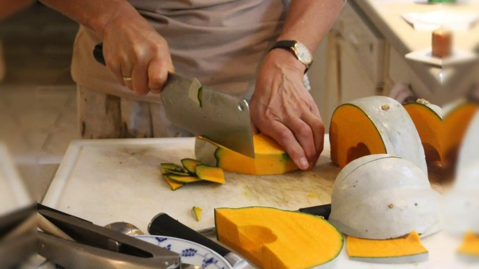 Mit einem Beil wird der Kürbis geteilt und anschließend von seiner harten Schale befreit. (Foto: Huss-Weber)