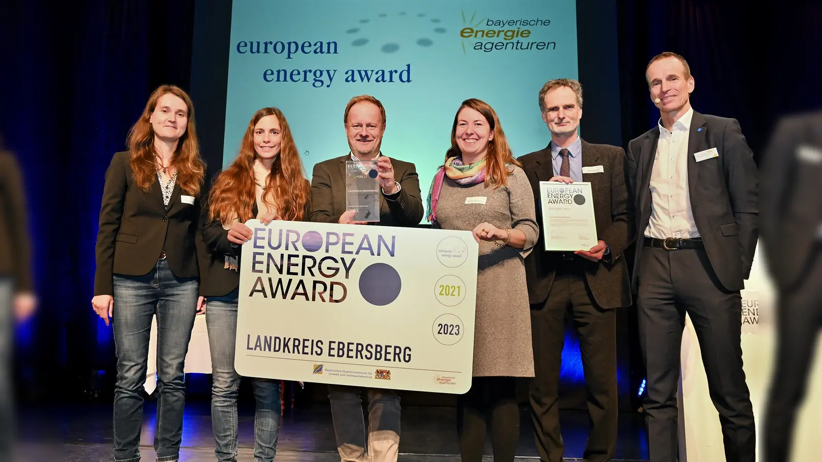 Dr. Mady Olonscheck (EEA), Dr. Lisa Ruetgers (Klimaschutzmanagerin LK Ebe), Landrat Robert Niedergesäß, Elisabeth Buchmann (EnergieagenturEbersberg-München gGmbH), Robert Winkler (Bayerisches Staatsministerium) und Martin Sambale (eza! Energie- &amp; Umweltzentrum Allgäu gemeinnützige GmbH) bei der Verleihung (v.l.). (Foto: Andreas Lode)