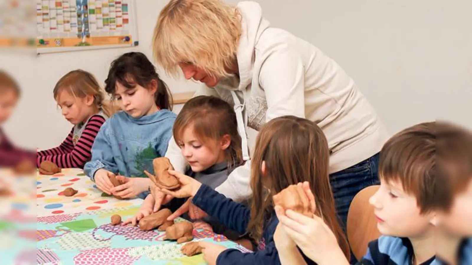 Bürgermeisterin Gabriele Müller töpfert gemeinsam mit den Grundschulkindern im Familienzentrum der Nachbarschaftshilfe Haar. 	 (Foto: Gemeinde Haar)