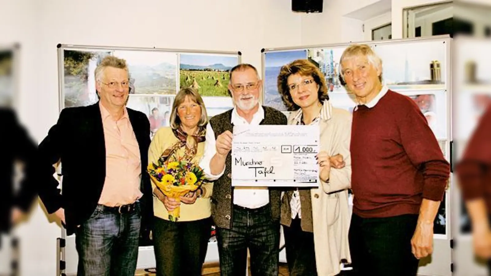 Walter Schmid (Mi.) erhält aus den Händen von Ingrid Lindner von der AG Moosach einen Scheck über 1000 Euro für die Münchner Tafel.	 (Foto: Photo Lehrer)