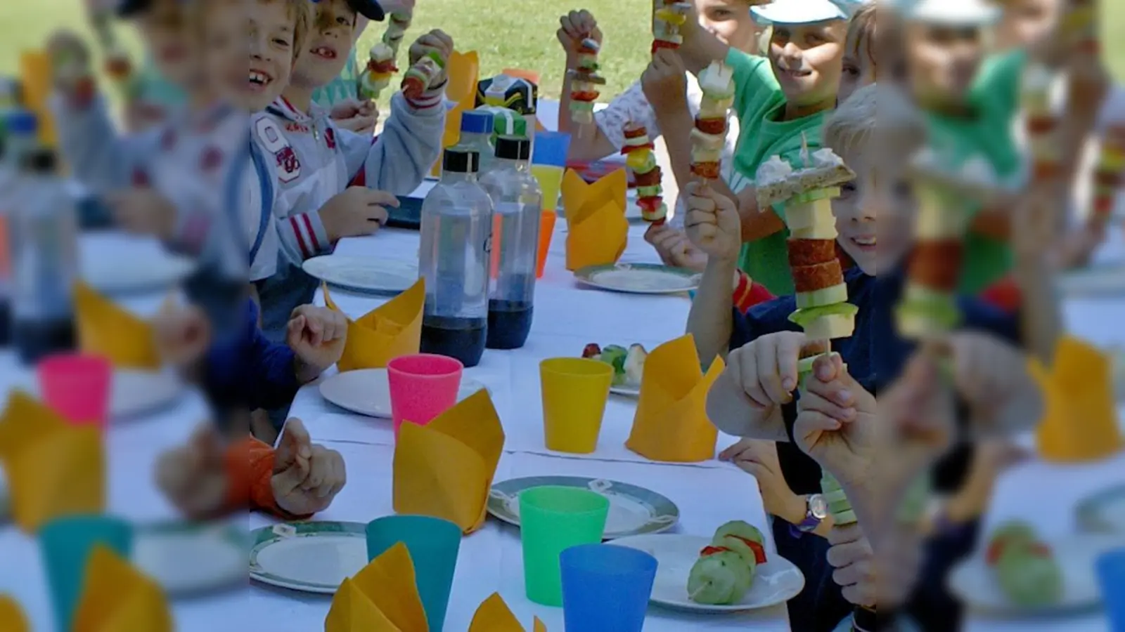 Wer so viel arbeitet, hämmert, sägt und spielt, muss sich auch stärken. Die Kinder beim Mittagessen am bunt gedeckten Tisch. (Foto: ASP)