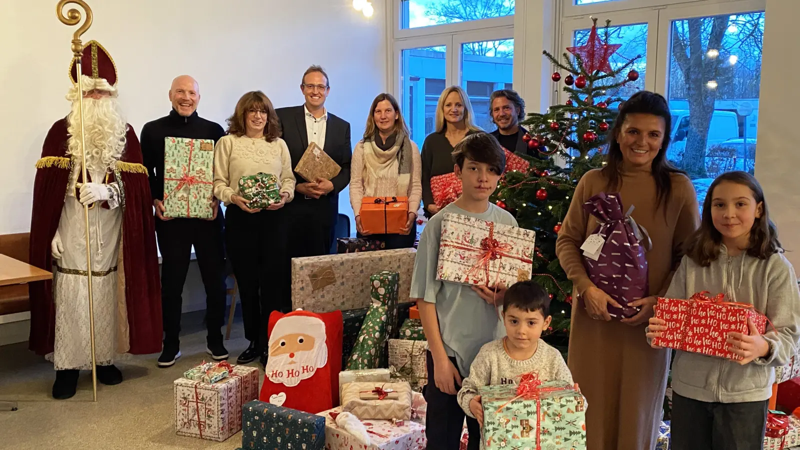 Matthias Sammer, Sabine Schlotterbeck, Thomas Moll, Andrea Wegener, Karin Sammer, Anton Schrobenhauser Junior und Stefanie Schrobenhauser zusammen mit Kindern aus dem Clemens-Maria-Kinderheim und dem Weihnachtsmann bei der Geschenkeübergabe.  (Foto: kids to life)