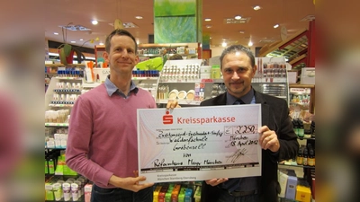 Reformhaus-Inhaber Michael Mayr (l.) übergibt Detlef Ludwig, Geschäftsführer des Trägervereins der Waldorfschule Gröbenzell, den Spendenscheck. (Foto: pi)