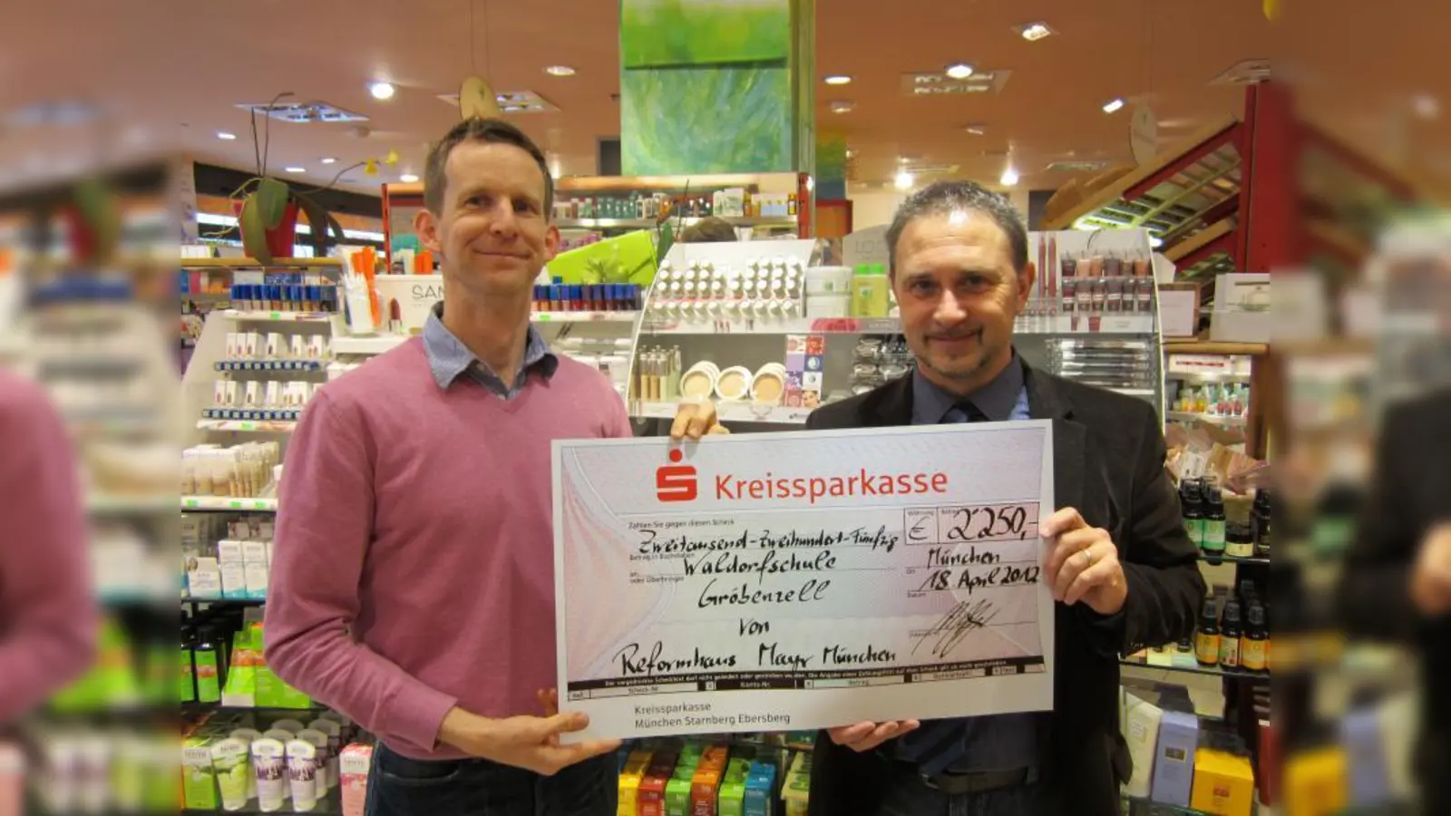 Reformhaus-Inhaber Michael Mayr (l.) übergibt Detlef Ludwig, Geschäftsführer des Trägervereins der Waldorfschule Gröbenzell, den Spendenscheck. (Foto: pi)