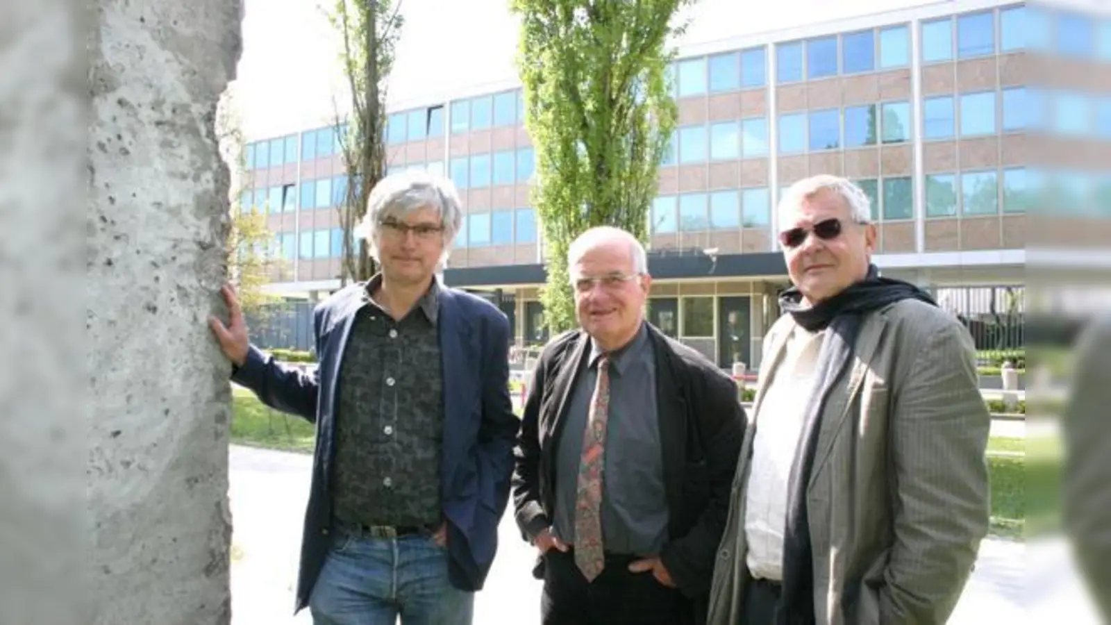 Für Hans Ulrich Käufl (BA Schwabing-Freimann), Oskar Holl (BA Maxvorstadt) und Werner Lederer-Piloty (BA Schwabing-Freimann) (v.l.) fast schon satirisch: Ein Stück der Berliner Mauer vor der trutzigen Festung des US-Konsulats. 	 (F.: ko)
