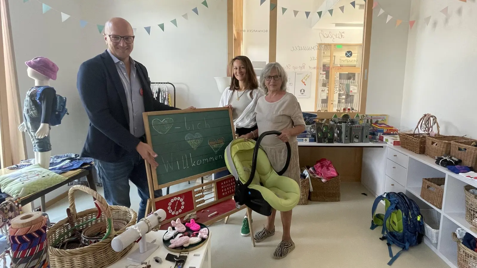 Im Kinder-Second-Hand-Laden „DUDA” der Nachbarschaftshilfe wird am 25. April gefeiert. Es freuen sich u.a. der Leiter der Nbh, Tobias Sicheneder, Alexandra Bitterwolf und Lotte Sturm auf viele Besucher. (Foto: hw)