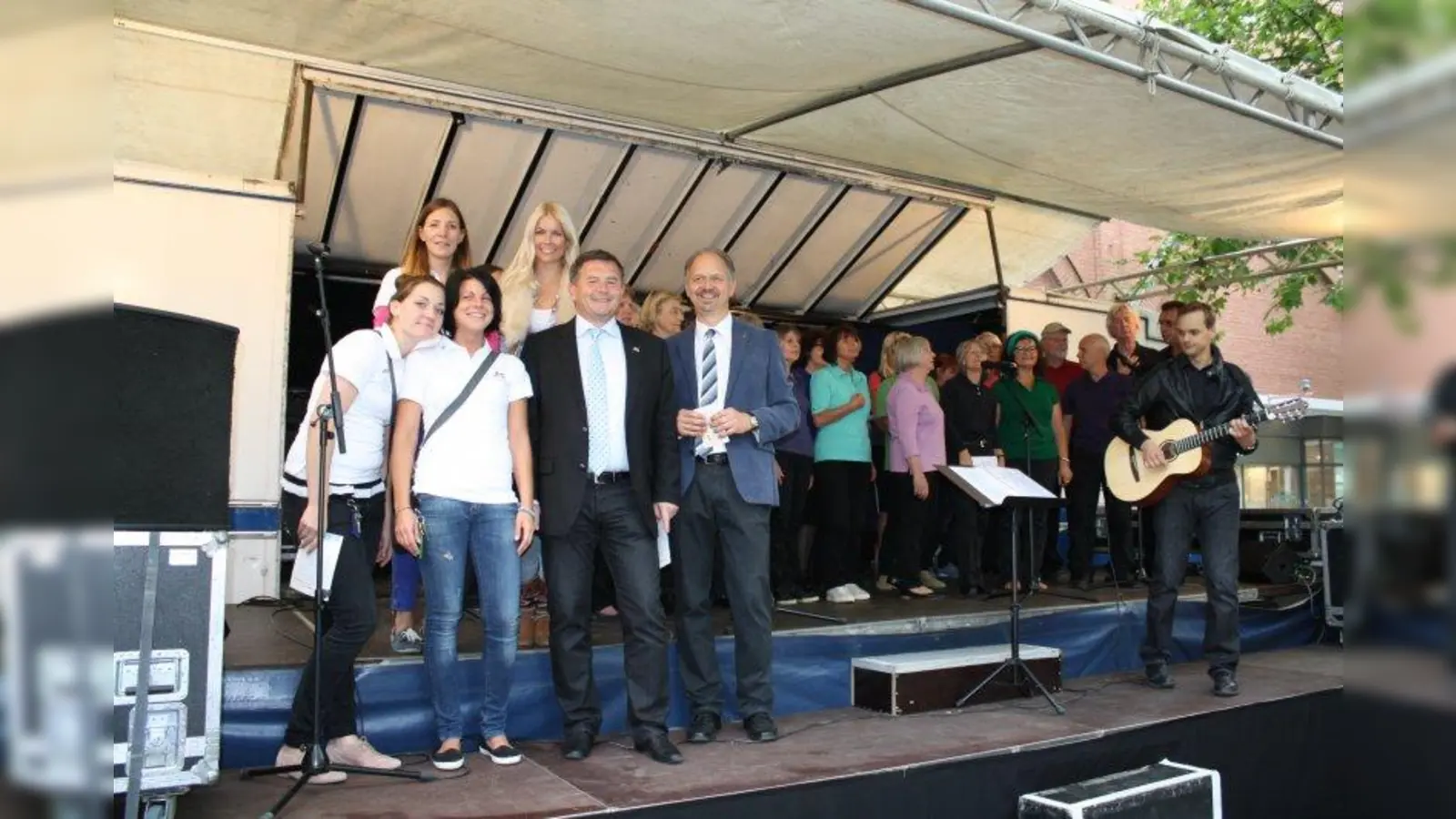 Auf dem Rotkreuzplatz gab es einen großes Fest. Erich Harsch, Vorsitzender der dm-Geschäftsführung (2.v.r.), zusammen mit dm-Filialleiterin Lydia Greiner (3.v.l.), ihrer Stellvertreterin Julia Grüger (2.v.l.) dm-Mitarbeiterin Julia Götz (li.), Moderatorin Tina Kaiser von Radio Gong 96,3 und dem dm-Gebietsverantwortlichen Bernd Kornmayer. Im Hintergrund sing der Chor des Seniorentreffs Neuhausen. (Foto: sb)