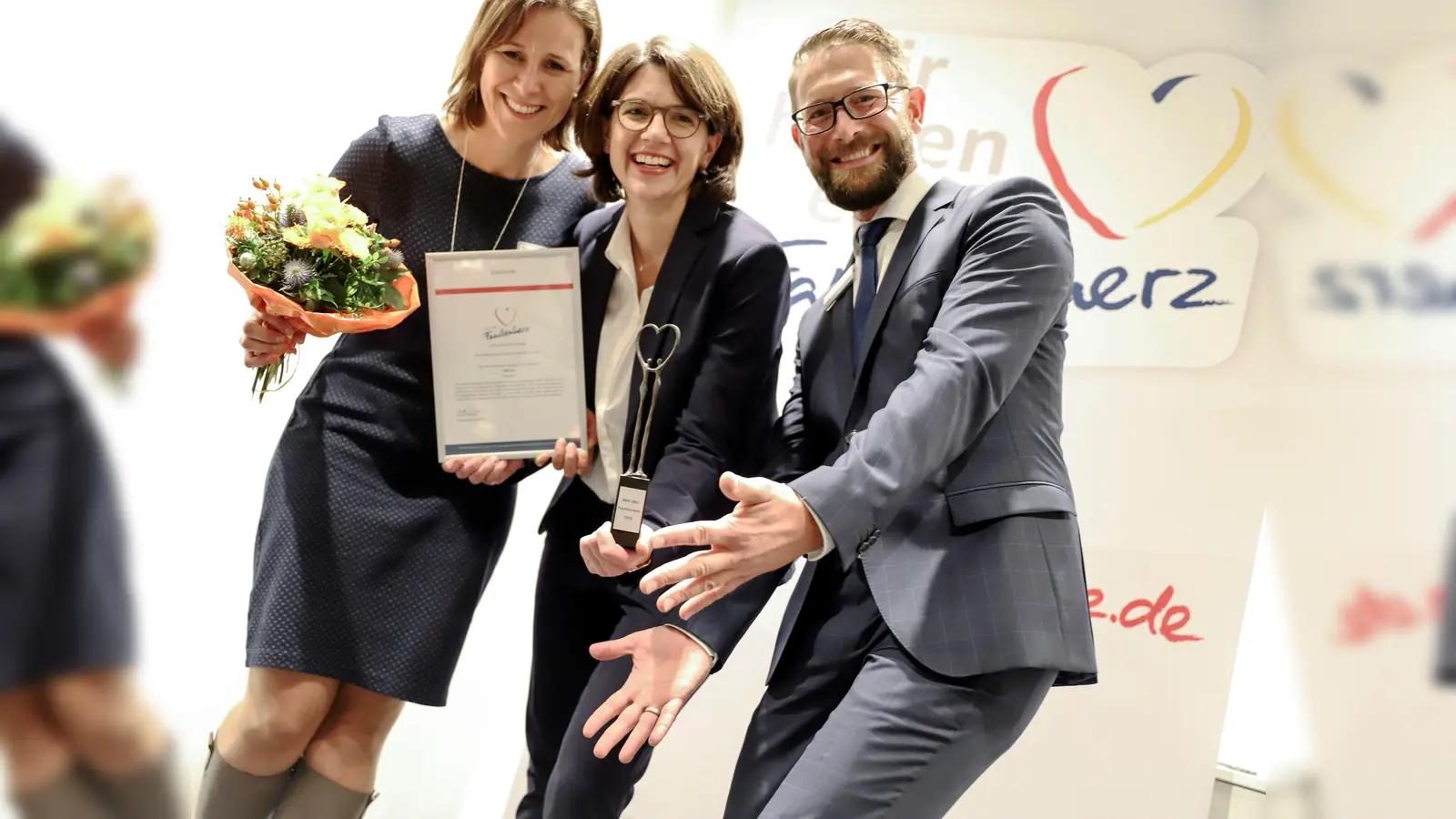 Spende plus Urkunde und Familienherz-Statue von Stefan Rank, Leiter ServiceCenter München der BKK·VBU, für Kerstin Pertzsch (l.) und Annabell Wegener, NBH-Ressortleitung Junge Familien.  (Foto: BKK VBU)
