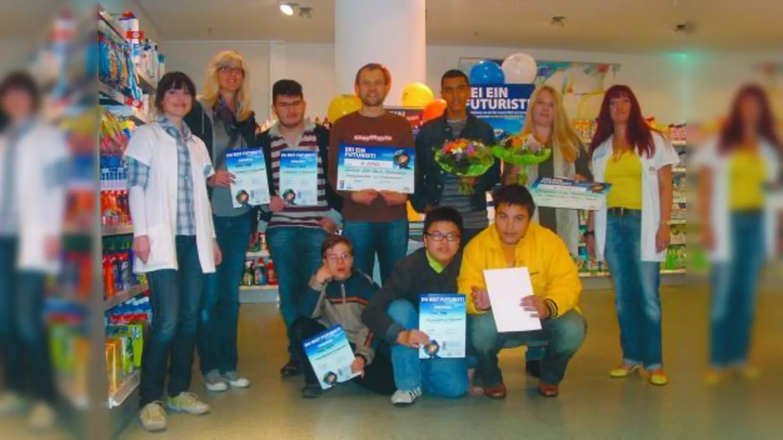 Eine ganze Gruppe von Jugendlichen aus der Mathilde-Eller-schule war zur Übergabe der Urkunden und des Schecks gekommen. V.l. stehend: Nicole Neunübel (stellv. dm-Filialleiterin), Astrid Wolf (Kinderpflegerin, Mathilde-Eller-Schule), Zvonimir Masic, Siegfried Grob (Projektleiter Mathilde-Eller-Schule), Nasser Ahmed, Sabine Leise (Förderverein der GS an der Bazeillesstraße) und dm-Filialleiterin Petra Vollath; vorne kniend v.l.: Markus Ferstl, Jassin Topen und Viet Tran. (Foto: bb)