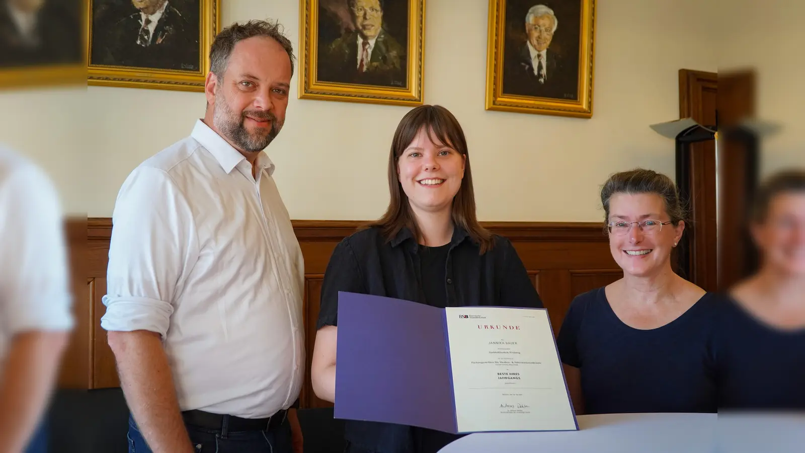 (v. l.) Oberbürgermeister Tobias Eschenbacher gratuliert Jannika Bauer zusammen mit Susanne Beck, Leiterin der Stadtbibliothek Freising, zu ihrem hervorragenden Abschluss. (Foto: Stadt Freising) (Foto: Stadt Freising)