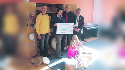 Christa Stock, Vorsitzende des Musikforums Blutenburg e.V., erhält von Thomas Hasselwander (li.), Schatzmeister der Bürgervereinigung Obermenzing e.V., Frieder Vogelsgesang (2.v.r.), Vorsitzender der Bürgervereinigung, und seinem Stellvertreter Ernst Eschenweck (re.) einen Scheck in Höhe von 3.800 Euro für die musikalische Früherziehung überreicht.Vorne im Bild: Elli (li.) und Letizia, zwei Schülerinnen des Musikforums. (Foto: Felix Vogelsgesang)