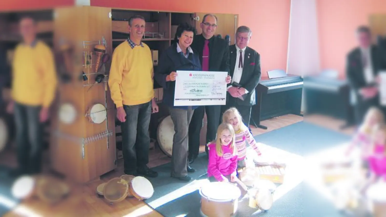 Christa Stock, Vorsitzende des Musikforums Blutenburg e.V., erhält von Thomas Hasselwander (li.), Schatzmeister der Bürgervereinigung Obermenzing e.V., Frieder Vogelsgesang (2.v.r.), Vorsitzender der Bürgervereinigung, und seinem Stellvertreter Ernst Eschenweck (re.) einen Scheck in Höhe von 3.800 Euro für die musikalische Früherziehung überreicht.Vorne im Bild: Elli (li.) und Letizia, zwei Schülerinnen des Musikforums. (Foto: Felix Vogelsgesang)
