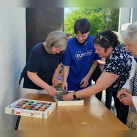 Pfarrgemeinderatsvorsitzende Dr. Andrea Hermann (1. v. l.) und Bücherei-Ehrenamtlicher Jakob Sunderer (2. v l.) legen die ersten Puzzleteile und eröffnen damit die neue Puzzle-Aktion in der Bücherei St. Martin in Germering. (Foto: St. Martin)