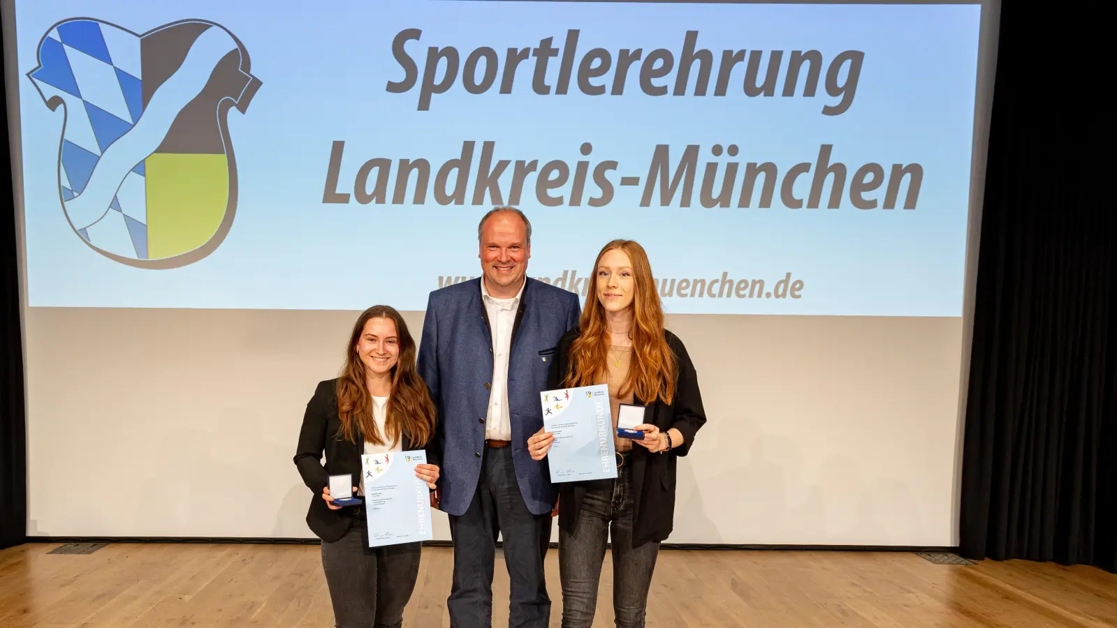 Landrat Christoph Göbel überreicht an Michelle Frank (l.) und Hannah Gasser (r.) vom FC Aschheim die verdienten Auszeichnungen.  (Foto: Robert Kinderle)
