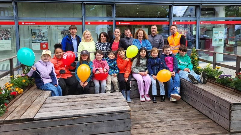 Freude über das neu bepflanzte Parklet: die Grundschulkinder mit Erstem Bürgermeister Felix Kempf (l.), Mitarbeiterinnen der Kreissparkasse, der Mobilitätsbeauftragten Martina Argyrakis sowie Mitarbeitern des gemeindlichen Bauhofs. (Foto: Gemeinde Planegg)