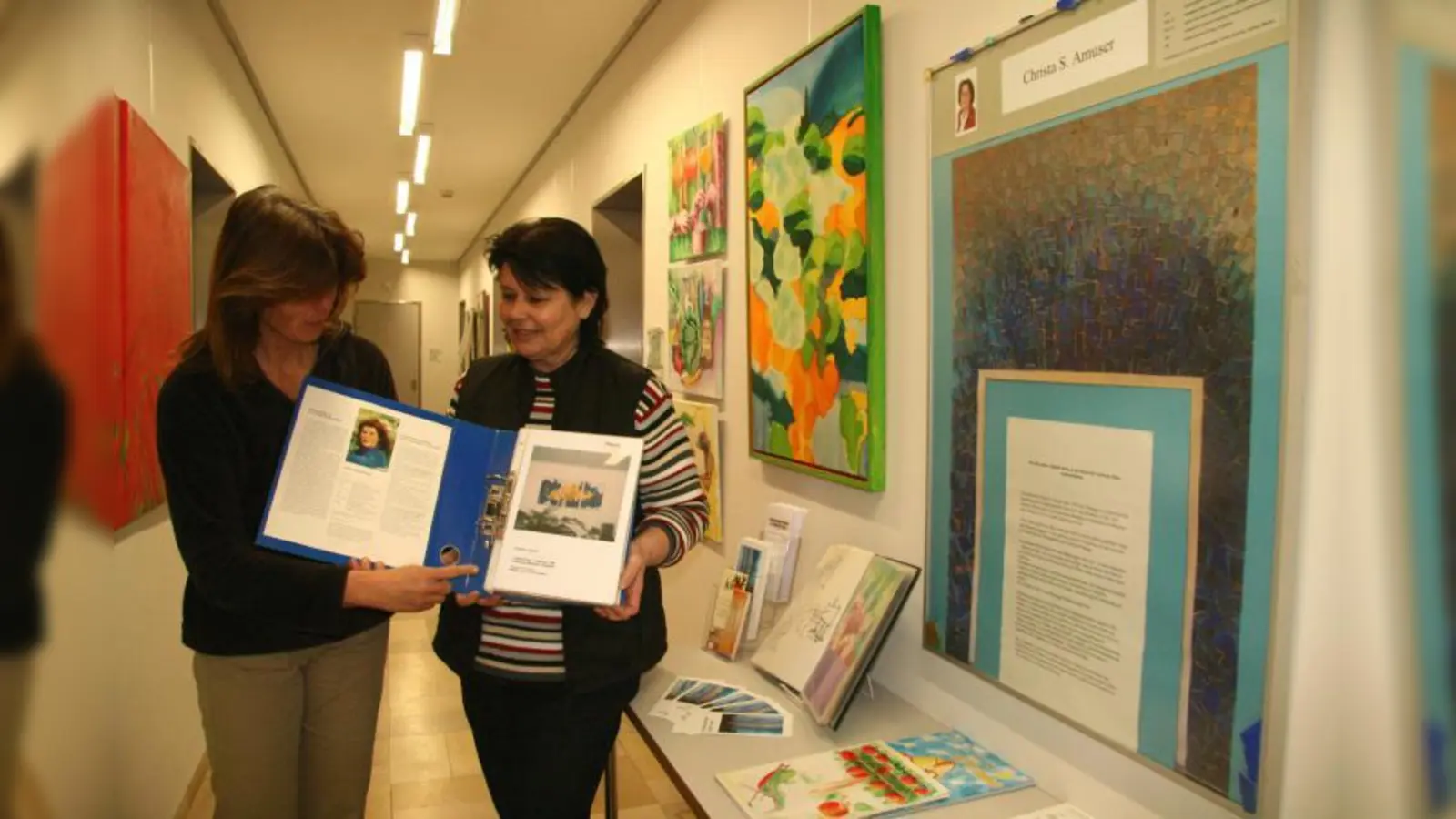 „Wir freuen uns außerordentlich, dass wir diese Ausstellung präsentieren können.“ Martina Irlbacher und Erika Klemt (v.l.) vom Gemeindearchiv verweisen auch auf das üppige Informationsmaterial über die Künstlerin Christa Amuser. (Foto: US)