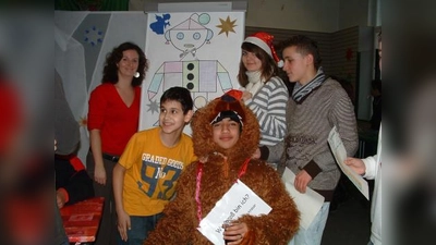 Mathematik einmal anders: Initiatorin Patricia Obermeier (l.) mit Schülern verschiedener Klassen und dem Weihnachtsbären vor der Station „Geoweihnachtsmann”. (Foto: bb)